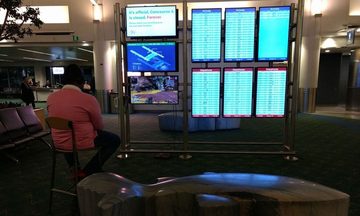 The gamer with an indomitable spirit, taking the airport screen to play games