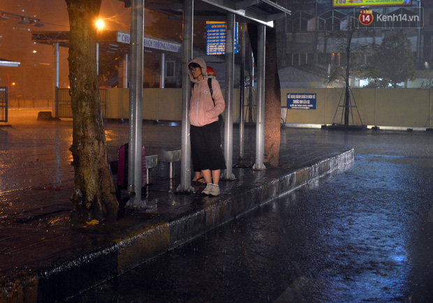 Only a few last passengers waiting for the final bus home under the rain.