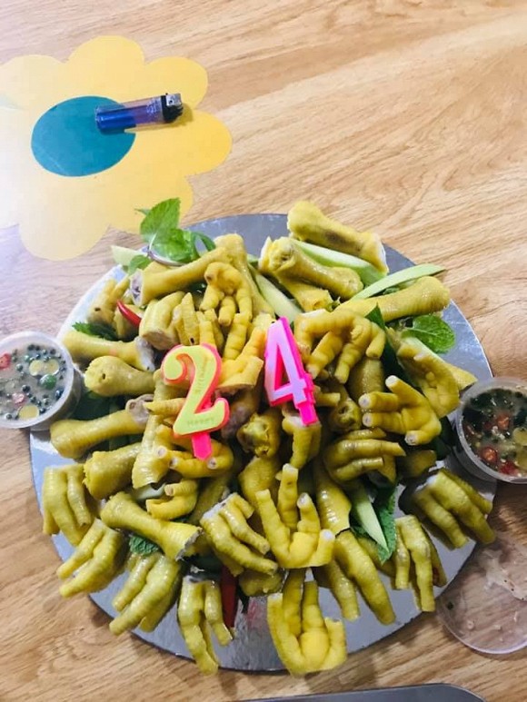 A birthday cake made entirely of chicken feet with two dipping sauces on either side.