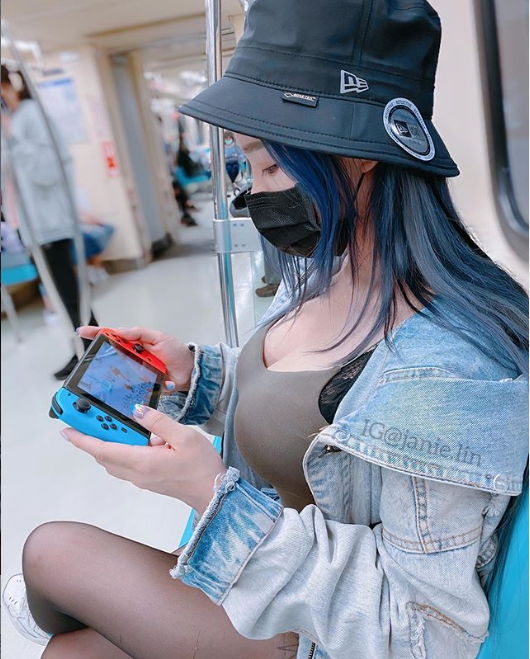 While sitting on the train, she still comfortably plays games on her Nintendo Switch.