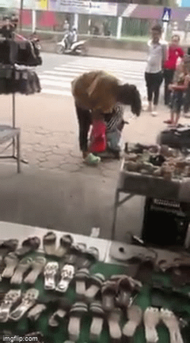 The young man kneeling on the street, hugging the girl's legs, crying and asking her to come back.