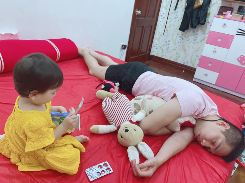 The baby plays while dad is sound asleep.