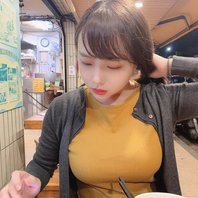 About a girl sitting and eating at a roadside stall