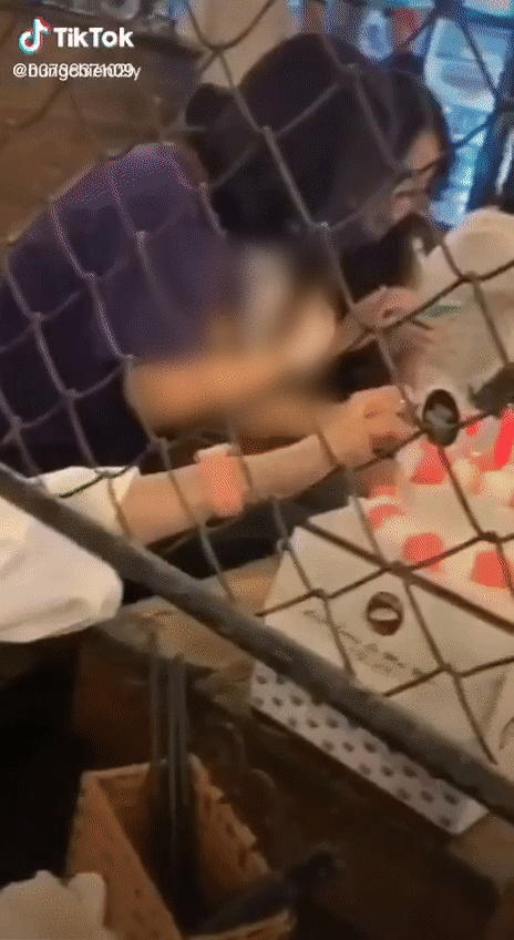 The girl carelessly swiped cake from the neighboring table and joyfully enjoyed it.