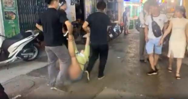 The woman being carried out by bar staff. Screenshot from the video
