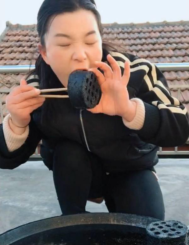 The female streamer excitedly enjoys her charcoal dish