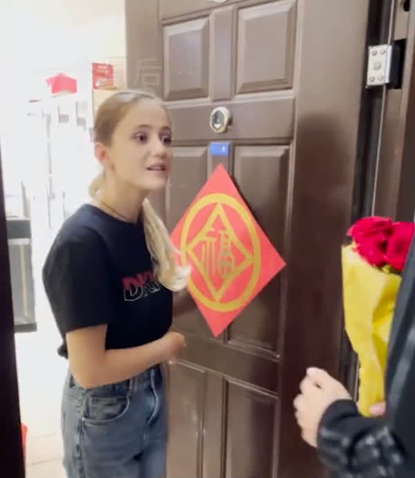 The young man knocking on the door to give flowers to the neighbor