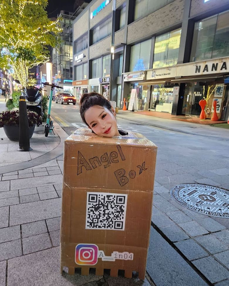 Hot Girl Punished by Court for Inviting Men to Touch Her Breasts in Public 2 She cut holes in the upper part of the box and invited men to touch her breasts.